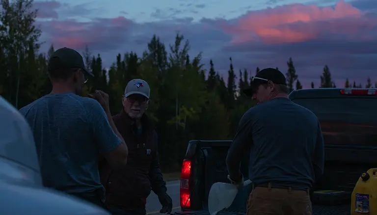 lake-harvested wild rice | Picture of a group of men putting a load of wild rice bags in the back of a pick up truck at sunset - Origins Wild Rice Co.